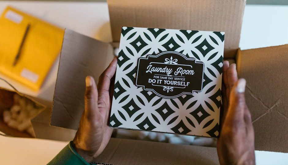 Cartão com design de 'Sala de Lavanderia' sobre uma caixa aberta, inspiração para projeto de decoração ou DIY.