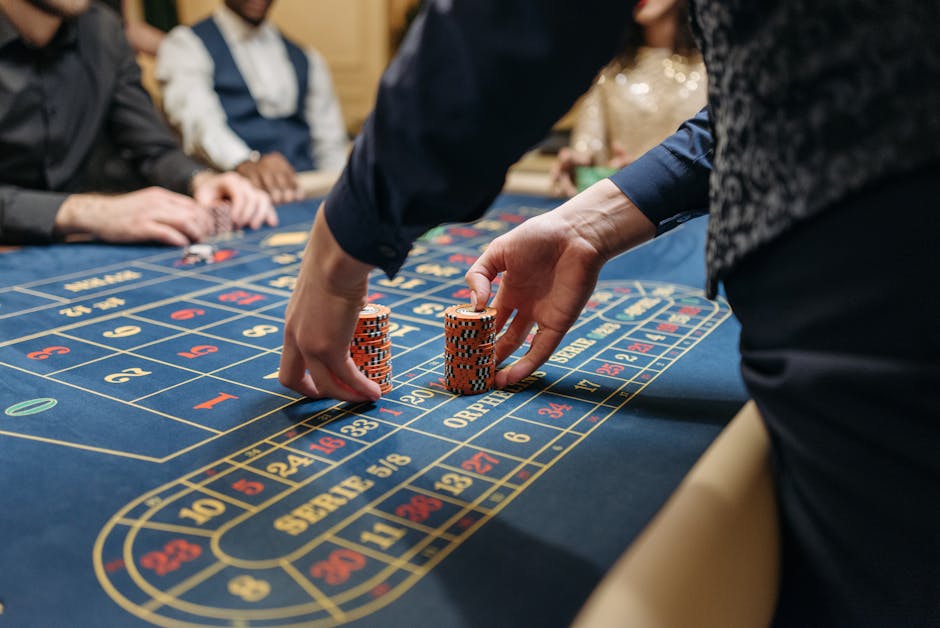 Jogadores apostando fichas em uma mesa de roleta azul em um cassino.