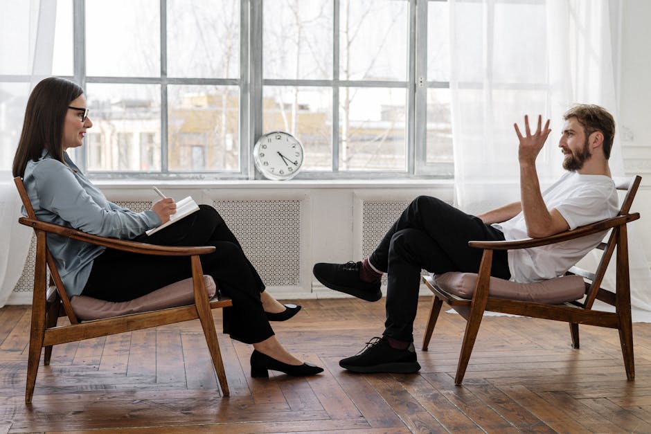 Um terapeuta conduzindo uma sessão de aconselhamento com um paciente masculino para apoiar a saúde mental.