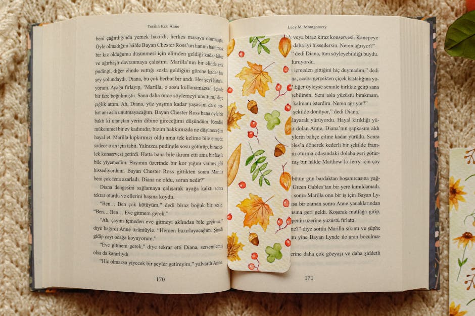 Livro aberto em um tapete aconchegante com marcador de folhas de outono coloridas.