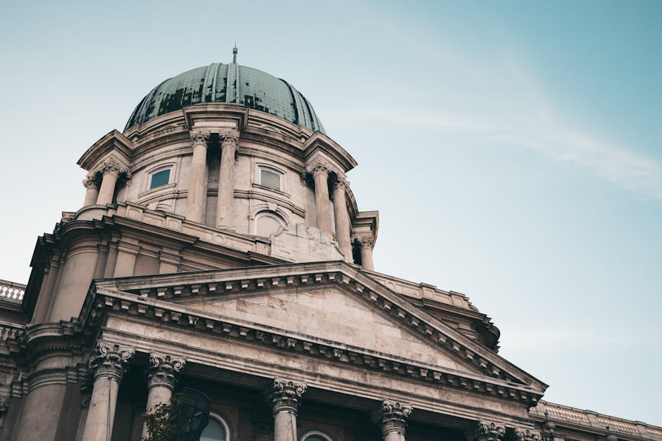 Cúpula histórica em Budapeste, Hungria, destacando sua grandiosidade sob um céu claro.