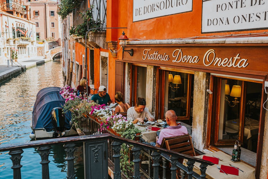 Restaurante aconchegante à beira de um canal em Veneza, com clientes desfrutando de uma refeição. Ideal para uma viagem de autoconhecimento.
