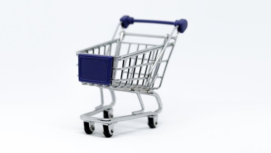 Um carrinho de compras moderno em miniatura em um fundo branco limpo, perfeito para conceitos de e-commerce.