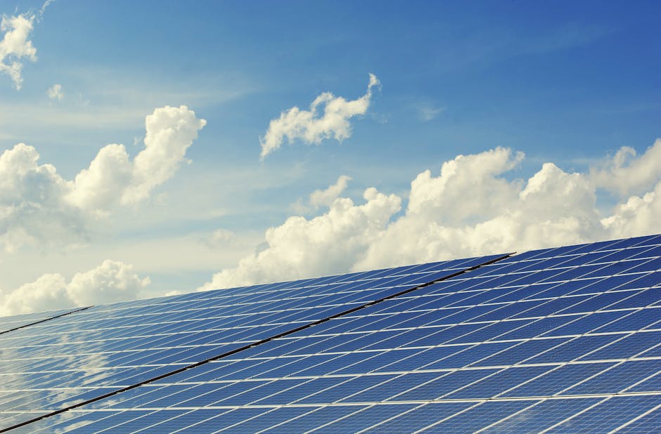 Painéis solares modernos sob um céu azul vibrante com nuvens, simbolizando energia limpa.