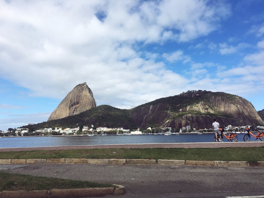 Vista do Pão de Açúcar a partir do bairro do Flamengo, Rio de Janeiro, com céu azul e vista para o mar.