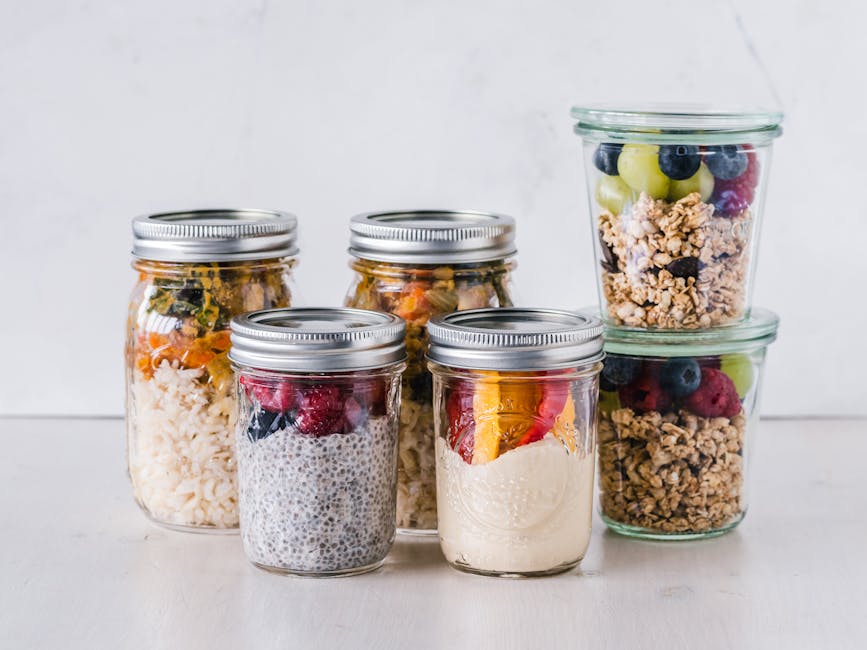Pote de vidro com camadas de açaí, granola, banana e mel, sob a luz do sol.