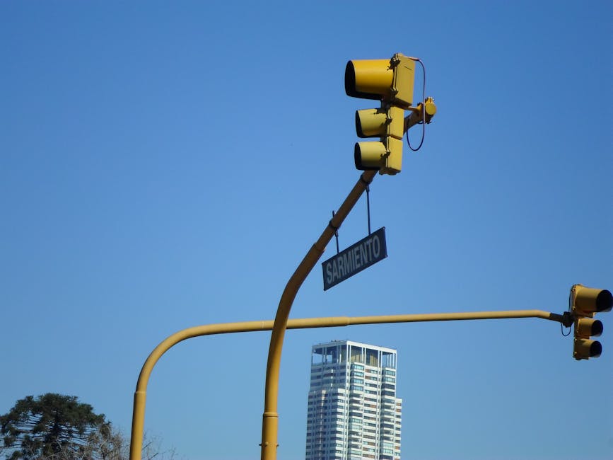 Placa de rua com o nome de Jeremy Sarmiento em uma cidade, sob um céu azul.