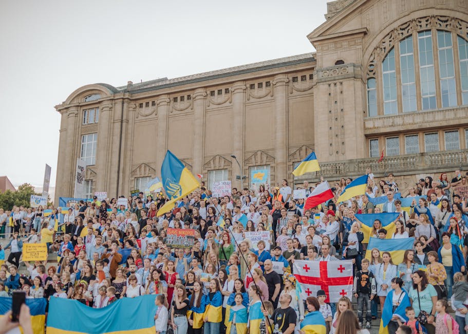 Manifestação pública na Rússia com multidão vibrante agitando bandeiras em apoio a Putin.
