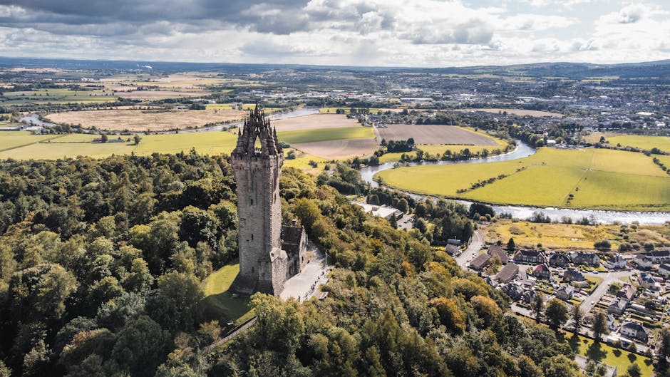 Paisagem verdejante com o Monumento a Wallace em Stirling, Escócia, em homenagem a Wallace Yan.