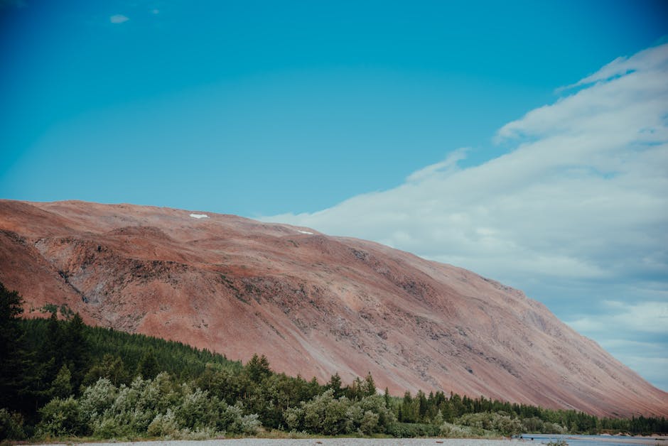 Vista deslumbrante das Montanhas Yamal com céu azul claro e vegetação exuberante.