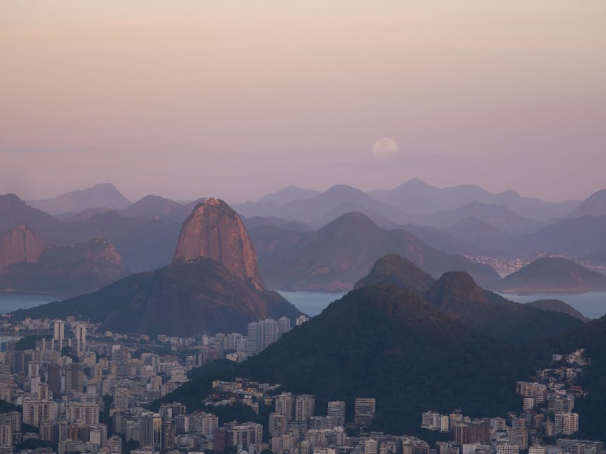 Jogadoras do Botafogo Feminino comemorando gol em campo durante o pôr do sol no Rio de Janeiro.