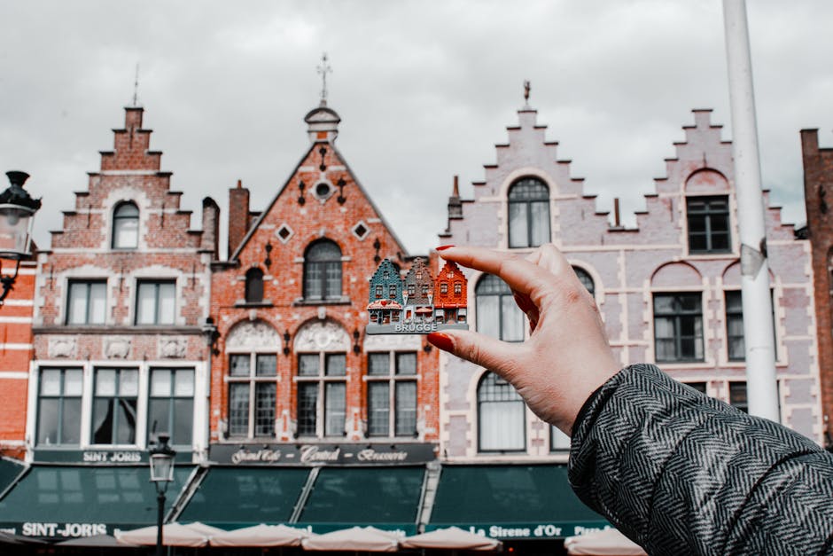 Escudo do Clube Brugge em miniatura com arquitetura belga ao fundo.