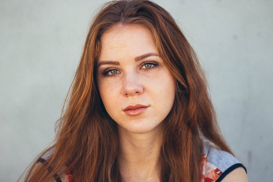 Retrato impressionante em close de uma jovem com cabelos vermelhos e olhos expressivos.