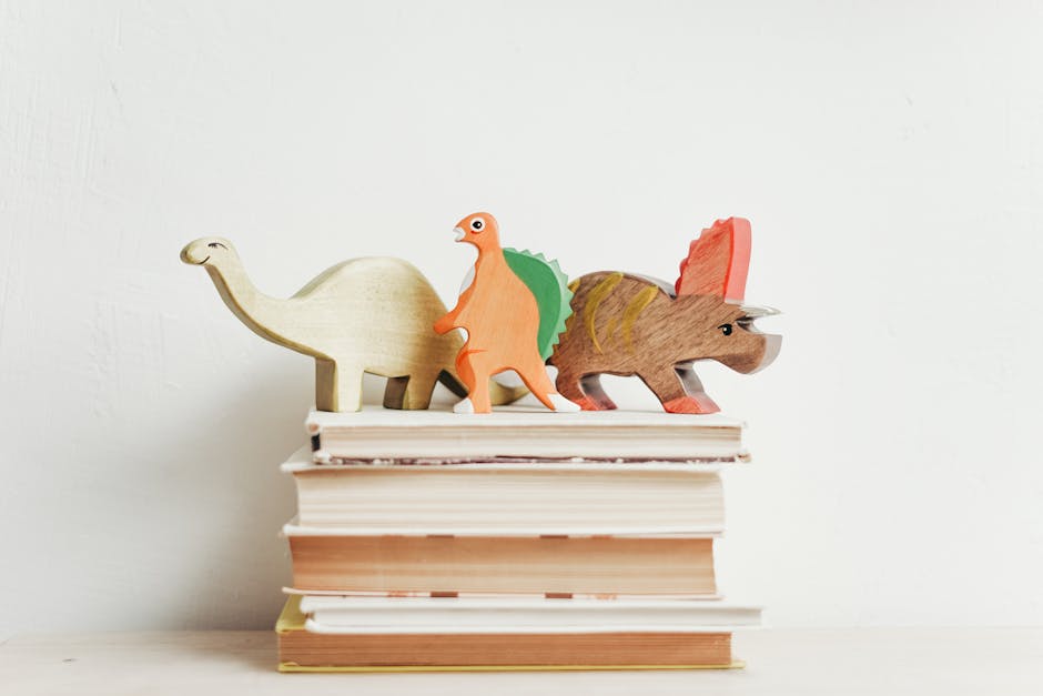 Livros empilhados com capas coloridas e dinossauros de madeira, representando a diversidade e força de Flávio Dino.