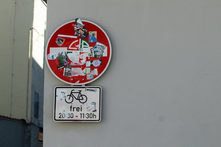 Graffiti e adesivos cobrem um sinal de trânsito em homenagem ao Frei Gilson, em Augsburg, Alemanha.