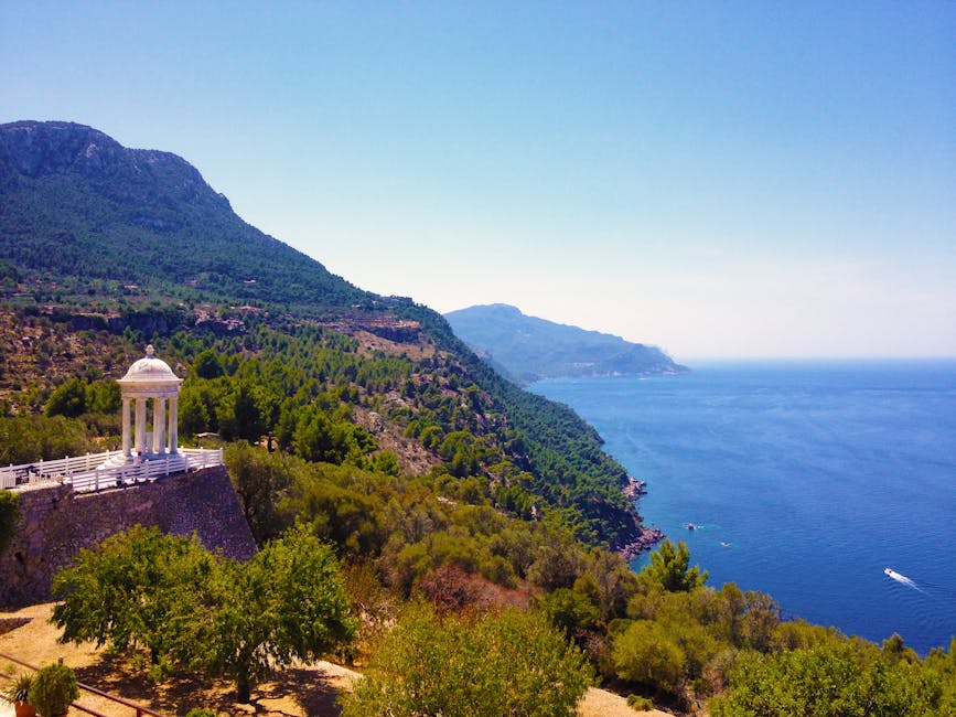 Costa de Mallorca com vista deslumbrante, pergolado tranquilo, vegetação exuberante e oceano azul.