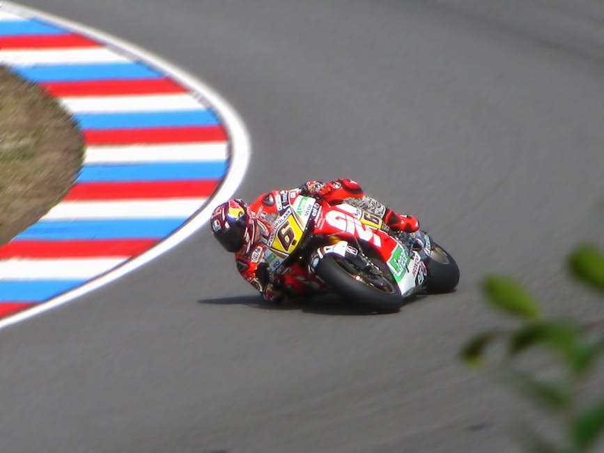 Piloto de motocicleta inclina-se em uma curva fechada em alta velocidade durante uma competição de MotoGP.