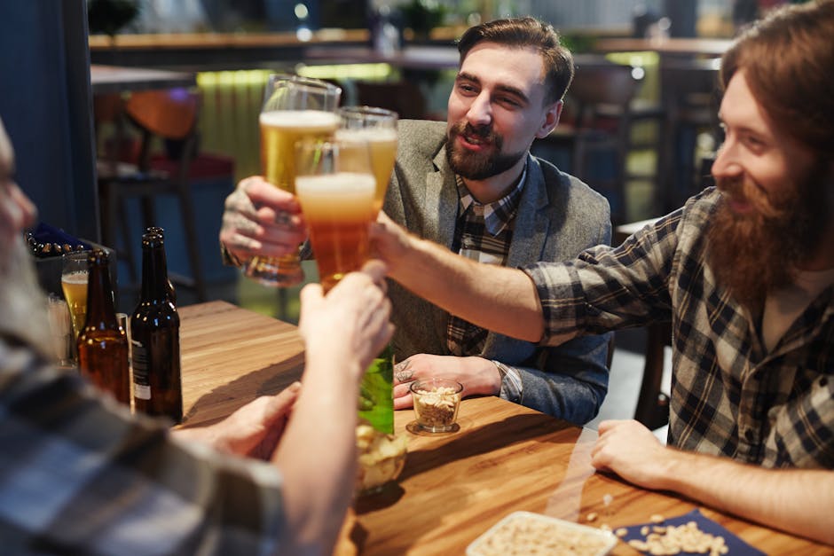 Grupo de amigos brindando com copos de cerveja enquanto celebram em um pub.
