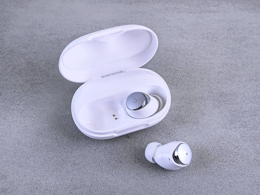 Fones de ouvido brancos sem fio e estojo de carregamento em uma superfície texturizada.