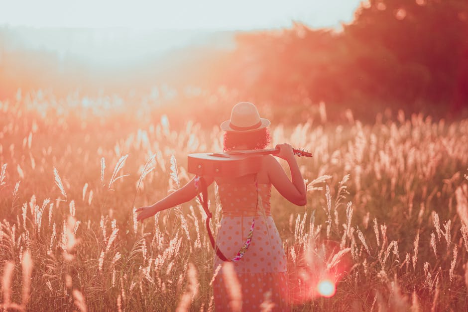 Mulher no campo ao pôr do sol segurando uma viola, vivendo a tranquilidade e liberdade do sertão.