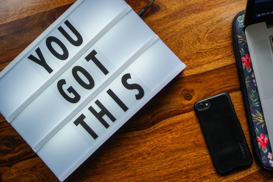 Frase motivacional 'Você consegue' em uma lightbox, smartphone em uma mesa de madeira, ambiente aconchegante.